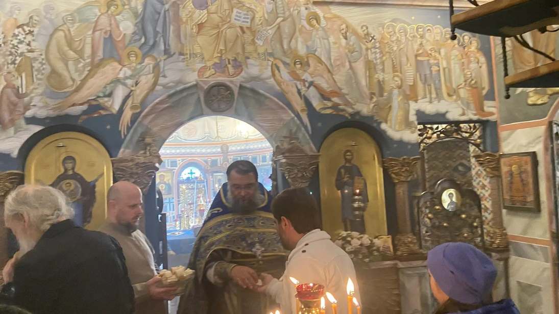 батюшка раздает просфоры на праздник Покрова